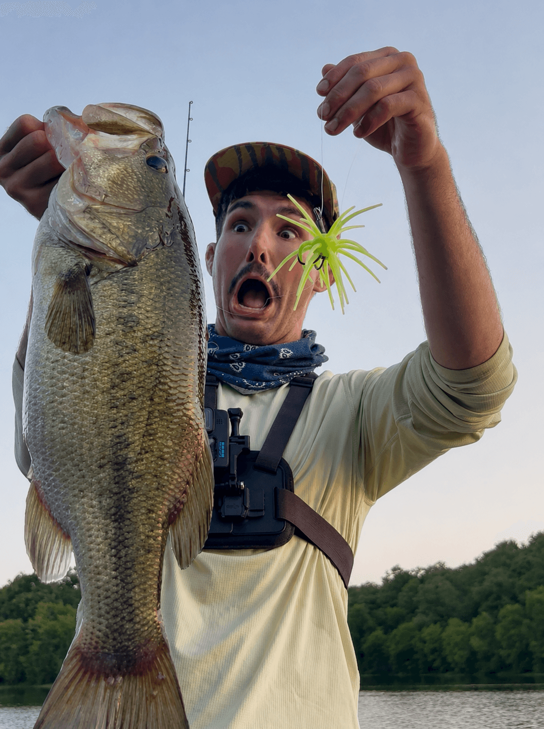 Creekkid, wide-eyed, holding up a big largemouth bass and the chartreuse jig that caught it